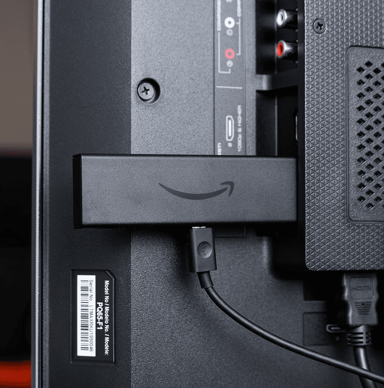 Fire TV Stick plugged into a TV with the Amazon home screen visible